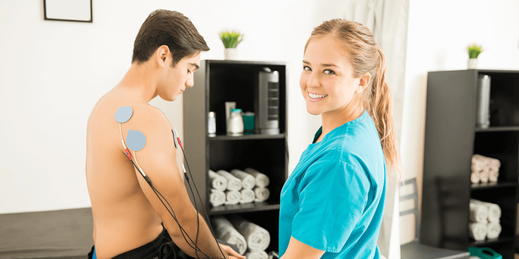 Physiotherapist placing electrodes on patient