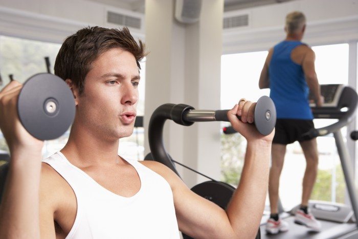 Man breathing between sets on the shoulder press machine