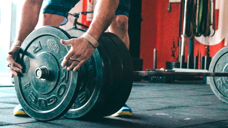 a person racking on weights to the bar