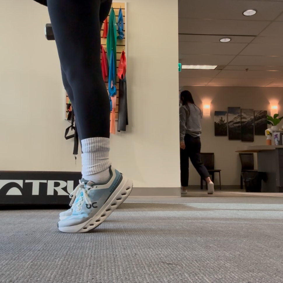 dumbbell calf raises demonstrated by physiotherapist assistant