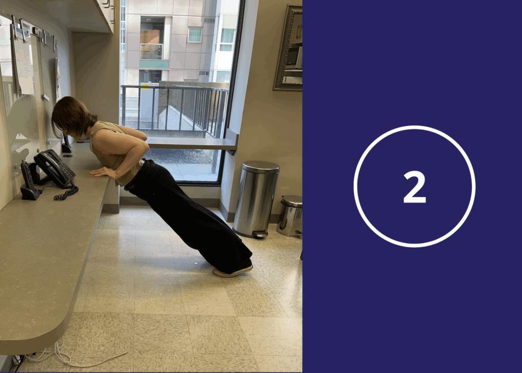 Step 2 of desk pushups demonstrated by a co-op student