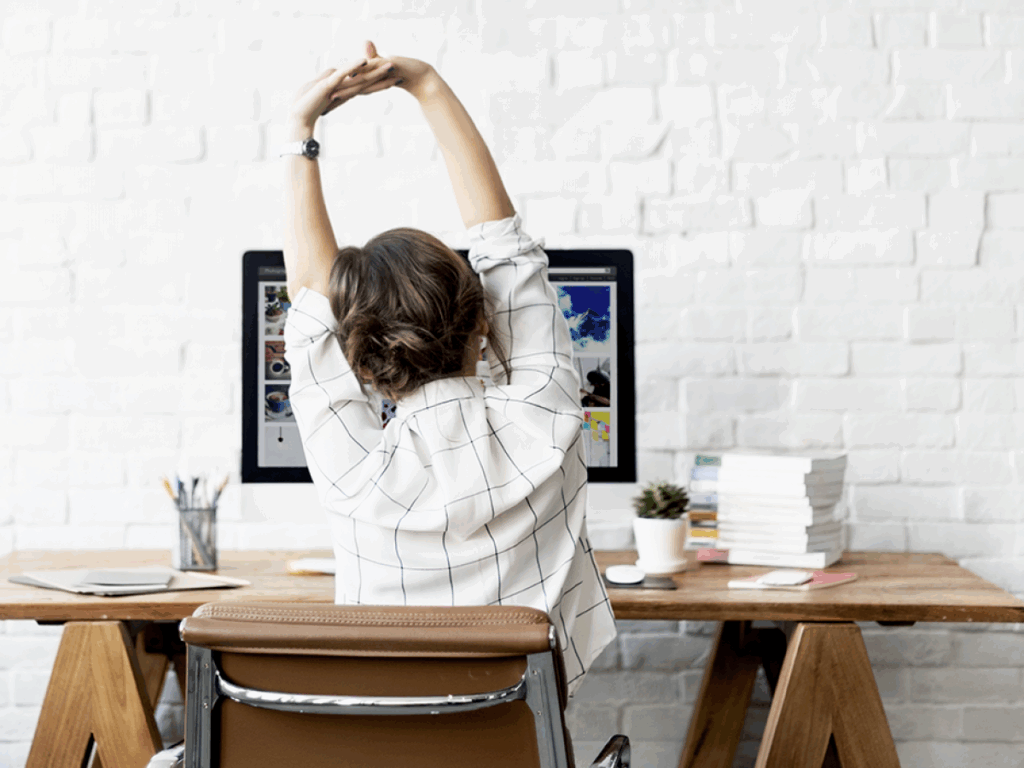 woman stretching back at desk
